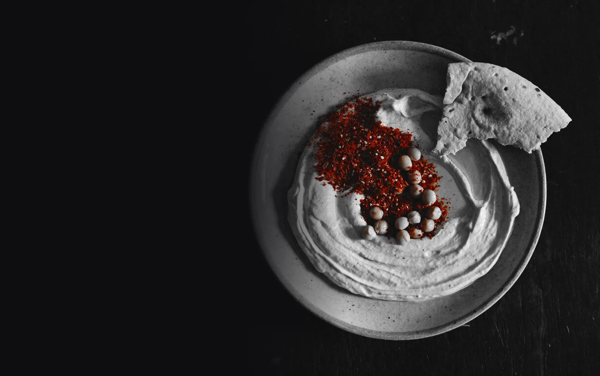 A plate of hummus with paprika and chickpeas